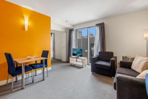 ein Wohnzimmer mit einem Sofa, einem Tisch und Stühlen in der Unterkunft Central Melbourne CBD Apartment by Crown Casino in Melbourne