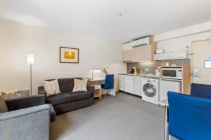 ein Wohnzimmer mit einem Sofa und einer Küche in der Unterkunft Central Melbourne CBD Apartment by Crown Casino in Melbourne