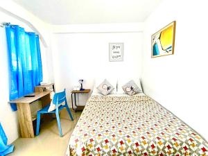 a bedroom with a bed and a desk and a chair at Treasure Beach in Carles