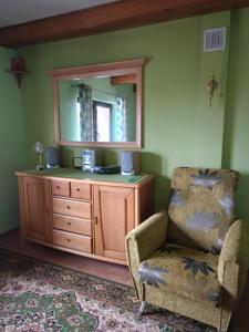 a room with a mirror and a chair and a dresser at Kornatka Hajnówka Pokoje Puszcza Białowieska in Hajnówka