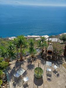 eine Terrasse mit Stühlen, einem Tisch und Meerblick in der Unterkunft Panoramic Villa in Amalfi in Amalfi