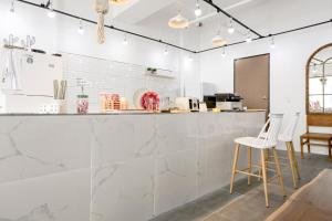 a kitchen with white marble countertops and white stools at W Hotel in Yangsan