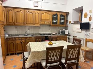 eine Küche mit Holzschränken und einem Tisch mit Stühlen in der Unterkunft Panoramic Villa in Amalfi in Amalfi