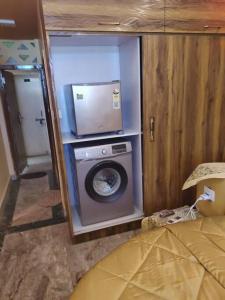 uma casa de banho com uma máquina de lavar roupa num quarto em My Uttrakhand Experiences em Haridwar