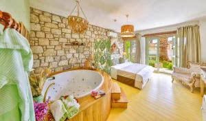 a large bathroom with a bath tub and a bedroom at Palas Alaçatı - Adult Only in Alaçatı