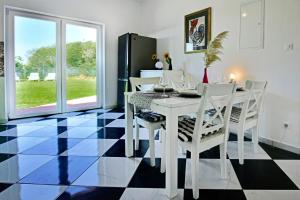 una sala da pranzo con tavolo e sedie bianchi di Casa Lavanda Vrsar shared Pool a Vrsar