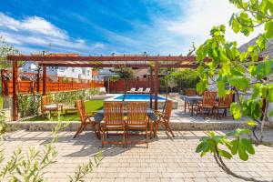a patio with a table and chairs and a pool at Home Away From Home with a heated pool in Punat