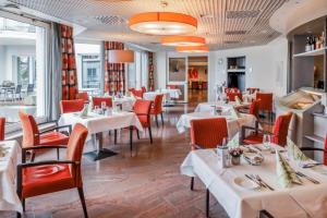 restauracja z białymi stołami i czerwonymi krzesłami w obiekcie Senioren-Residenz Segeten w Zurychu
