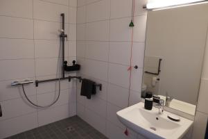 uma casa de banho branca com um chuveiro e um lavatório. em ISA Rheinquartier - Moderne und barrierefreie Ferienapartments em Lahnstein