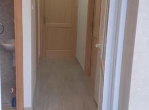 a hallway leading to a bathroom with a sink and a door at Apartment Sanja in Slano