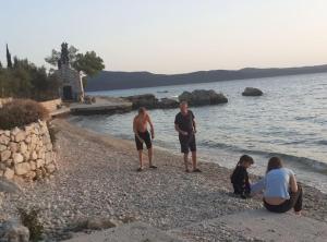 a group of people standing on a rocky beach at Apartment Sanja in Slano