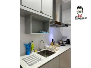 una cucina con lavandino e piano di lavoro di Staycation Homestay 19 Riverine Petanak Apartment a Kuching