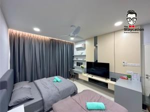 una camera con letto e TV di Staycation Homestay 19 Riverine Petanak Apartment a Kuching