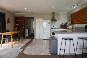 a kitchen with a table and chairs and a refrigerator at Comfortable Home, Big Backyard in Rotorua