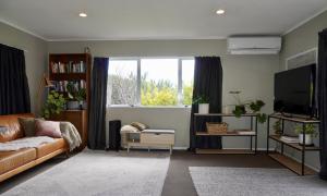 a living room with a couch and a television at Comfortable Home, Big Backyard in Rotorua