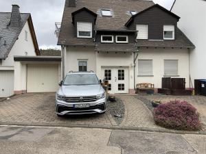 a white car parked in front of a house at Ferienwohnung Dieblich in Dieblich