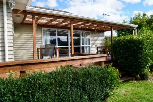 una terraza con mesa y sillas en una casa en Comfortable Home, Big Backyard en Rotorua