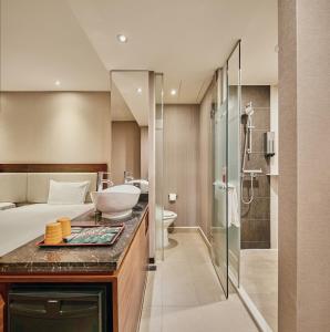 a bathroom with a bed and a sink and a shower at Orange Hotel - Linsen, Taipei in Taipei
