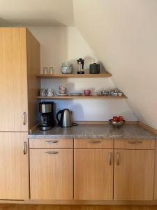 a kitchen with wooden cabinets and a counter top at Haus Wittensee in Bünsdorf