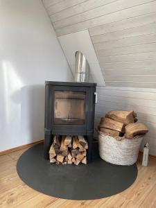 a fireplace in a room with a pile of wood at Haus Wittensee in Bünsdorf