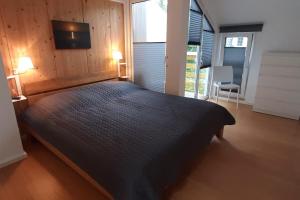 1 dormitorio con 1 cama y TV en la pared en Ferienhaus SommarStuga, en Wiek auf Rügen
