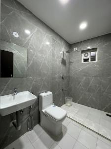 a bathroom with a white toilet and a sink at Sangeetha Business Hotel in Chennai