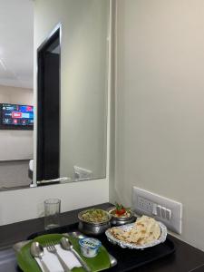 a kitchen counter with some food on a table at Sangeetha Business Hotel in Chennai