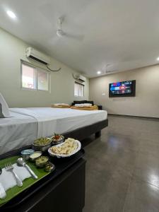 a hotel room with a large bed and a tray of food at Sangeetha Business Hotel in Chennai