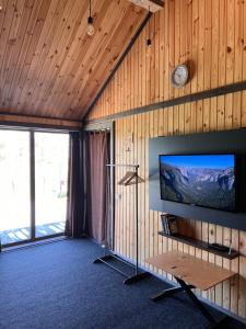a living room with a flat screen tv on a wooden wall at СвояХата in Svityazʼ