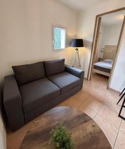 - un salon avec un canapé et un miroir dans l'établissement Charmante maisonnette situé au calme proche d'Ajaccio., à Afa