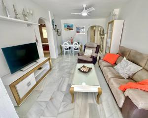 a living room with a couch and a flat screen tv at Refugio Costero Tu Hogar vistas al Mar con Parking in Calahonda