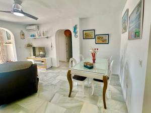 a living room with a table and a couch at Refugio Costero Tu Hogar vistas al Mar con Parking in Calahonda