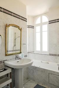 La salle de bains est pourvue d'un lavabo, d'une baignoire et d'un miroir. dans l'établissement Hotel K'Loys, à Paimpol