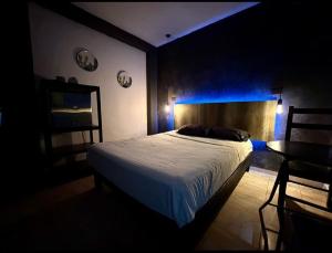 ein Schlafzimmer mit einem Bett und einem Tisch mit blauem Licht in der Unterkunft Zyan Rooms in Villahermosa