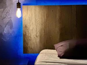 a bedroom with a bed and a blue light at Zyan Rooms in Villahermosa