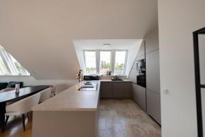 a kitchen with white cabinets and a large island at Luxury Penthouse Schönbrunn in Vienna