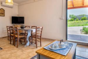 a dining room with a table and chairs and a television at The Secret Path in Sorso