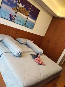 a bed with two stuffed animals on it in a bedroom at gold coast pik BEACH ROOM 1br netflix wifi sofa bed in Jakarta