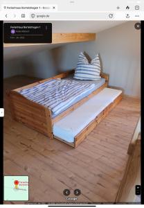 a bed with a wooden frame on the floor at Ferienhaus Bartelshagen 1 in Marlow