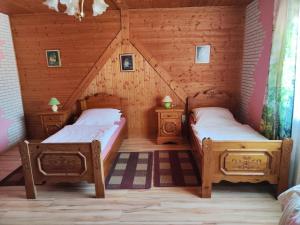 a bedroom with two beds in a wooden house at Pension Hubertushöhe in Kulmbach