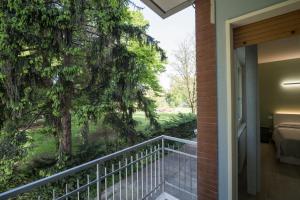 un balcón con vistas a un dormitorio y a un árbol en B&B Al Parco, en Verona
