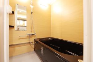 a bathroom with a black tub and a mirror at MolinHotels702 アクティビティを満喫できる札幌定山渓 天然温泉付-1L2Room K-Bed1&W-beds3 8persons in Jozankei