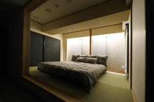 a bedroom with a bed in a room with a window at MolinHotels702 アクティビティを満喫できる札幌定山渓 天然温泉付-1L2Room K-Bed1&W-beds3 8persons in Jozankei