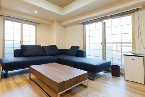 a living room with a blue couch and a coffee table at MolinHotels702 アクティビティを満喫できる札幌定山渓 天然温泉付-1L2Room K-Bed1&W-beds3 8persons in Jozankei