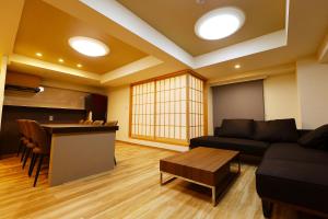 a living room with a couch and a table at MolinHotels702 アクティビティを満喫できる札幌定山渓 天然温泉付-1L2Room K-Bed1&W-beds3 8persons in Jozankei