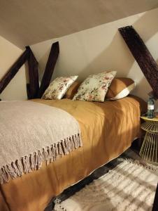 a bed with pillows in a corner of a room at Le logis de Bodard in Chinon