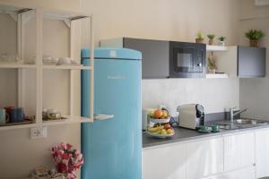 a blue refrigerator in a kitchen with a bowl of fruit at B&B Al Parco in Verona