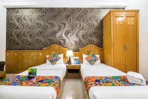 Cette chambre comprend 2 lits et un mur. dans l'établissement Hotel Kochar Continental, à New Delhi