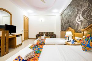 Cette chambre comprend 2 lits et une télévision à écran plat. dans l'établissement Hotel Kochar Continental, à New Delhi