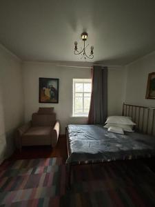 ein Schlafzimmer mit einem Bett, einem Stuhl und einem Fenster in der Unterkunft Гостевой дом «Орман» in Qarqaraly